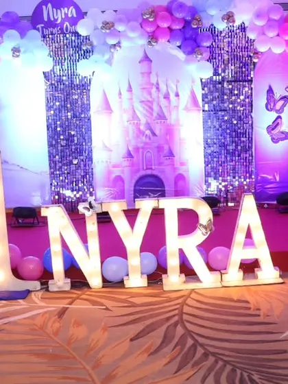 The birthday girl, Nyra, celebrating her first birthday on her princess castle-themed stage.