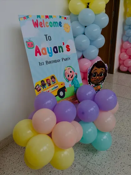 A Cocomelon-themed welcome board surrounded by colorful pastel balloons. The design is bright, cheerful, and perfect for a first birthday party.
