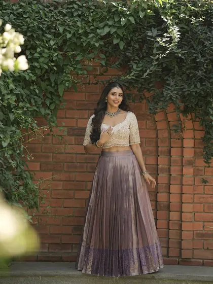 A full view of the lavender and ivory half saree, worn by actress Sapthami Gowda. A perfect blend of modern style and traditional grace.