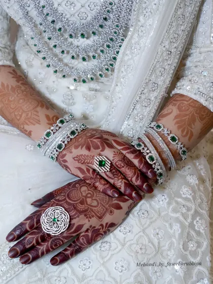 A posed shot highlighting the beautiful henna stain and the bride's elegant rings and bangles.