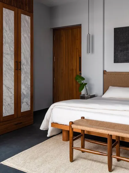 Wardrobe shutters in the master bedroom, featuring panels of marble inlaid within a solid wood frame. This is a design I created to elevate a functional item into a luxurious feature, blending stone and wood.