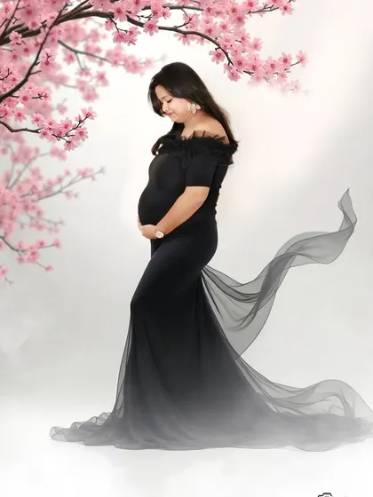 A graceful side-profile shot in a black gown with a flowing train. The cherry blossom branches add a delicate, artistic touch to this elegant studio portrait.