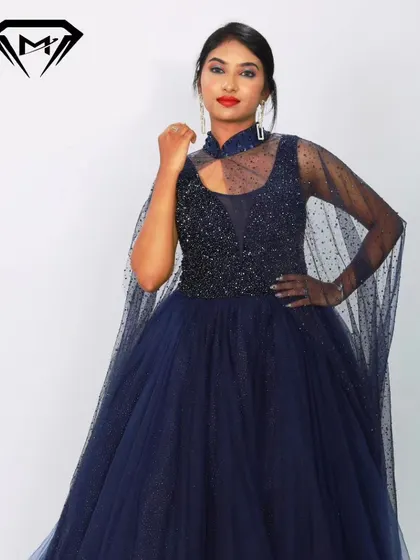 A close-up of the navy blue gown's beaded bodice and high-neck cape detail. The craftsmanship is designed to make you feel like royalty.