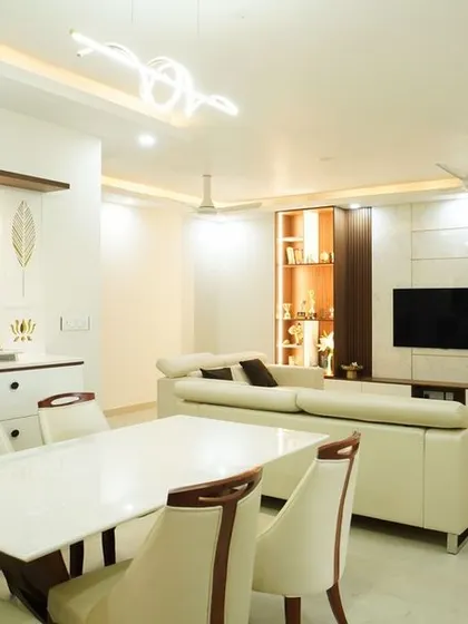 A luxurious open-plan living and dining area with high-end finishes. The space features a custom TV unit, an elegant dining set, and a sophisticated crockery cabinet.