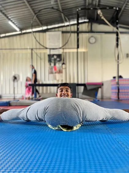 Taking the split to the next level. This student demonstrates a pancake stretch, an advanced flexibility skill that requires open hips and a flexible spine.