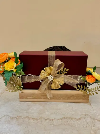 'Shaadi ke Tohfe' should be as special as the occasion. This is an example of my trousseau packing, where a simple gift box is elevated with a wooden tray, golden floral accents, and an elegant bow.