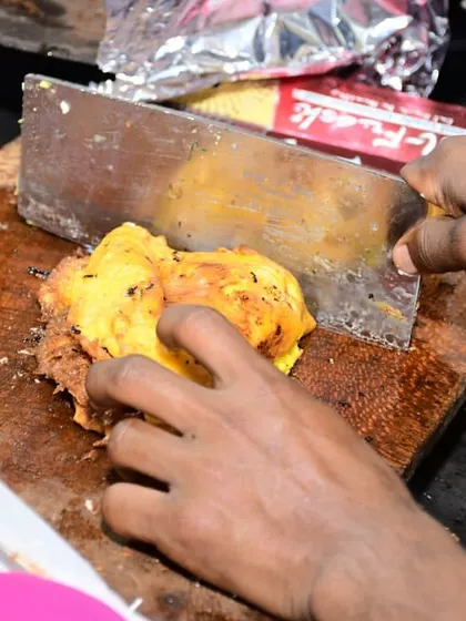 Our chef expertly chopping ingredients on a wooden board, getting them ready for one of our signature tava preparations.