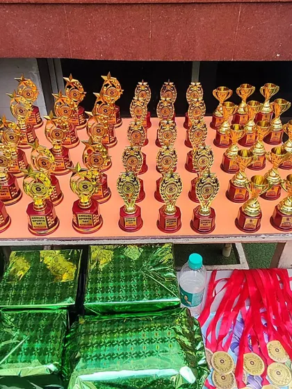 A table laden with gleaming trophies and medals for our Sports Day winners and participants. We believe in recognizing and rewarding effort and sportsmanship.