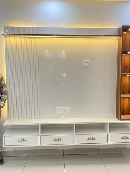 Here I am with a finished TV cabinet. This design features a large white back panel with fluted accents and a vertical wooden display shelf with integrated lighting.