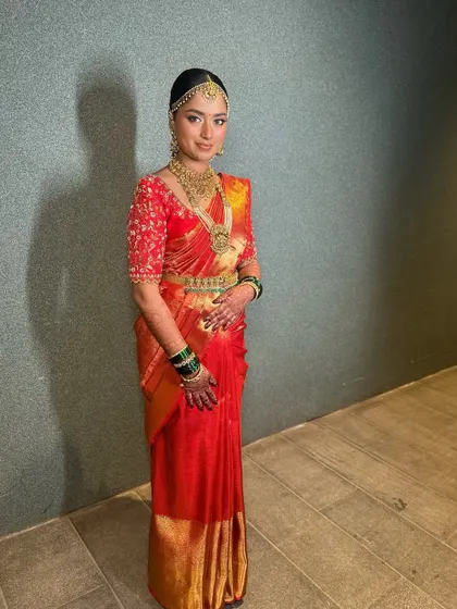 A full-length view of this bride's regal look in her red silk saree, showcasing the perfect drape and her confident posture.
