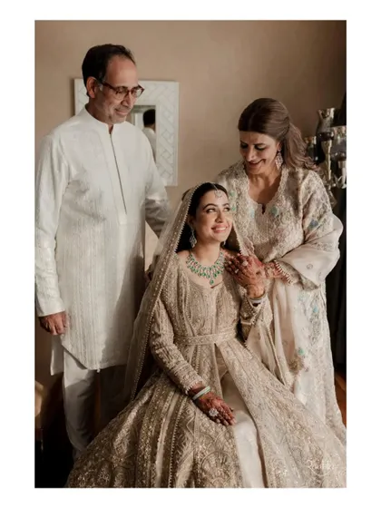 A beautiful family portrait of the bride with her parents before the ceremony in Kashmir, a moment filled with pride and love.