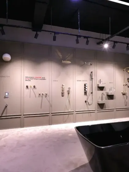 This angle reveals how the gallery wall integrates with other displays, like a freestanding black bathtub, creating a cohesive showroom experience. The layout allows for both focused product comparison and holistic design inspiration.