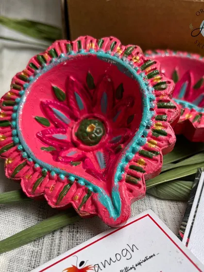 The vibrant pink and teal hand-painted diyas are a highlight of my festive hampers. Each one is painted with care by artisans at a partner NGO, adding a touch of traditional art to your celebrations.