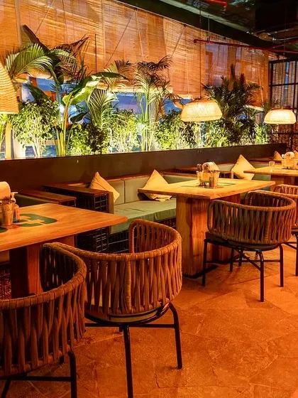 A shot of the dining area at Social Offline, showing the warm lighting and natural textures of the chairs and tables.