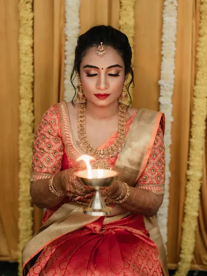 For Dr. Pooja's bangle ceremony, we went for a classic and elegant look. The makeup features a defined eye and a bold red lip, perfectly matching her beautiful silk saree and traditional gold jewellery.