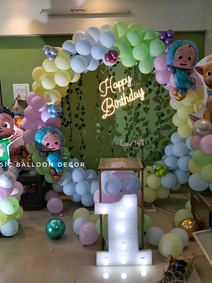 Another angle of the pastel Cocomelon theme, showing the arrangement of the character cutouts and the soft lighting from the marquee number.
