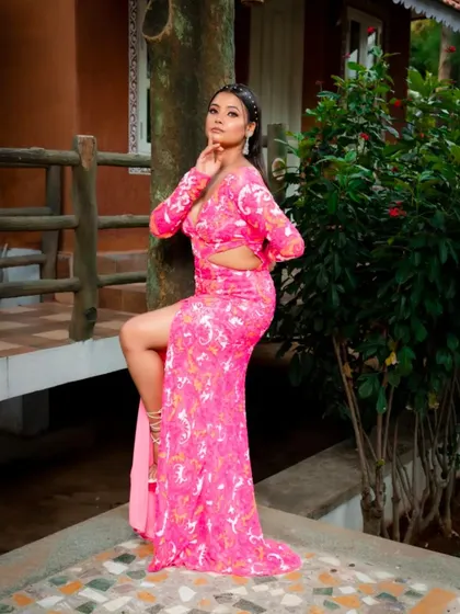 A powerful and fashionable pose in the pink patterned gown, perfect for making a statement.