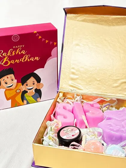Here is one of our beautiful Raksha Bandhan hampers, designed to make your sister feel truly special. This gift box includes personalized 'SIS' letter soaps, a unicorn soap, mini bath bombs, and an organic lip balm, all packed in a festive magnet box.