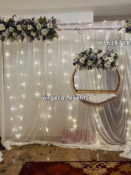 A simple and pure Naming Ceremony decor with a white fairy light curtain and a delicate floral arch.