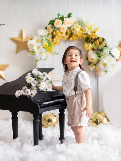 A joyful moment by the piano in a celestial-themed shoot. The combination of props creates a unique and imaginative story.