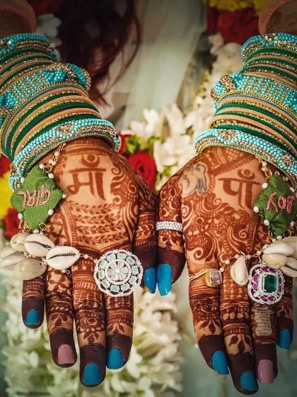 This baby shower henna is adorned with beautiful floral jewelry. The design includes tributes to the parents with 'Maa' and 'Paa' written on the back of the hands, celebrating their new roles.