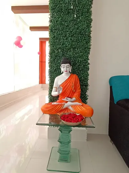 I created a calming corner in this spa-like interior by wrapping a structural pillar with an artificial green wall. Paired with a Buddha statue, it establishes a peaceful and serene atmosphere.
