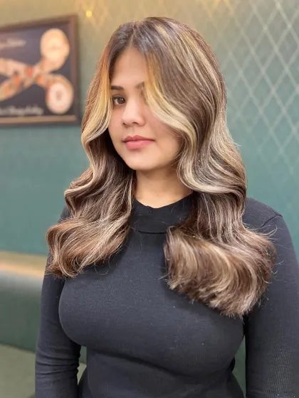 A frontal view of the brownish-blonde look with a money piece. The contrast between the dark and light tones creates a striking and trendy effect.