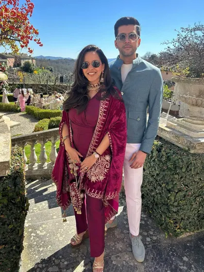 This look is tailored for travel and destination weddings. A client wears a custom teal double-breasted jacket with muted pink trousers, blending modern tailoring with a festive feel.