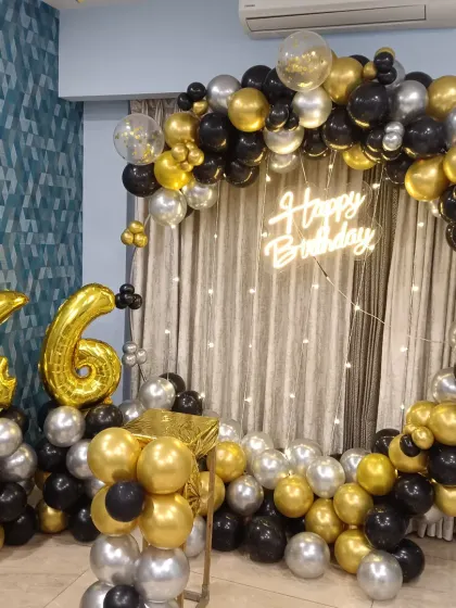 A classic and popular choice for adult birthdays, this black, gold, and silver balloon ring is set against a curtain with fairy lights. I also included large gold foil balloons to display the age, in this case, '46'.