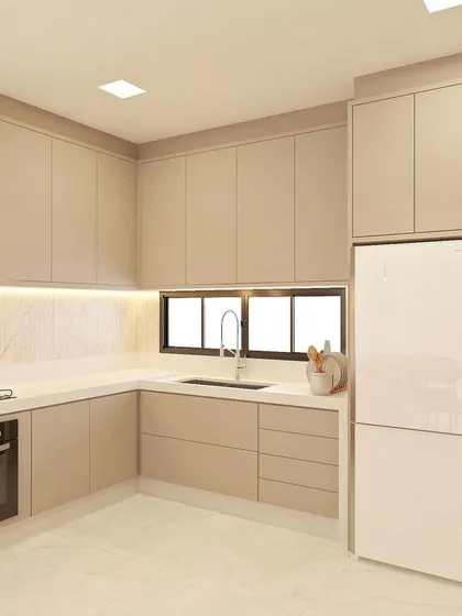 A complete view of the L-shaped beige kitchen layout, showing how we integrate the refrigerator seamlessly into the cabinetry.