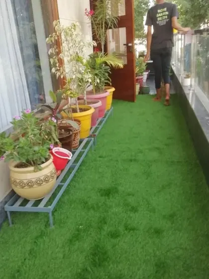 A full view of the transformed Gurgaon balcony. The artificial grass makes the space look bigger and brighter, connecting the indoors with a touch of nature.