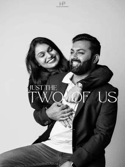 A timeless black and white portrait with the text 'Just The Two Of Us'. The focus is on the couple's joyful interaction, creating a classic and heartfelt image.