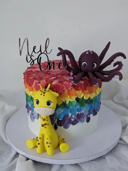 This was Neil's very first birthday cake! A vibrant rainbow design topped with his favorite toys at the time, a giraffe and an octopus.