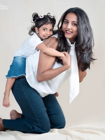 A mother and daughter share a fun piggyback ride. Their coordinated outfits and happy smiles make this a perfect candid portrait.