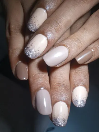 A beautiful glitter ombre French manicure. The silver glitter fades gently down from the tip over a nude base, creating a soft yet glamorous effect.