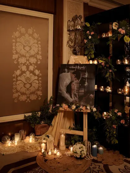 A romantic and personalized corner for an engagement party. We set up an easel with the couple's photo, surrounded by a sea of candles, strings of pearls, and delicate floral arrangements.