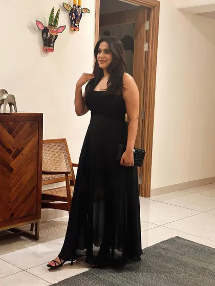 A full-length view of Sanjana's custom black gown, showcasing its flowing chiffon skirt and fitted velvet bodice.