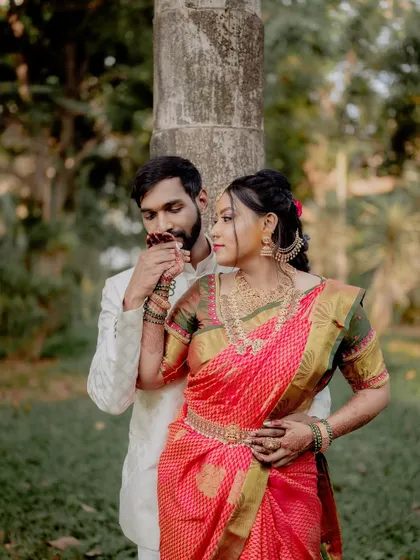 A gentle, romantic gesture. This shot captures the groom's tenderness and the bride's serene expression, highlighting the details of her henna-adorned hand.
