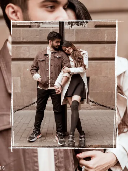 A creative framed shot, focusing on the couple's affectionate pose.