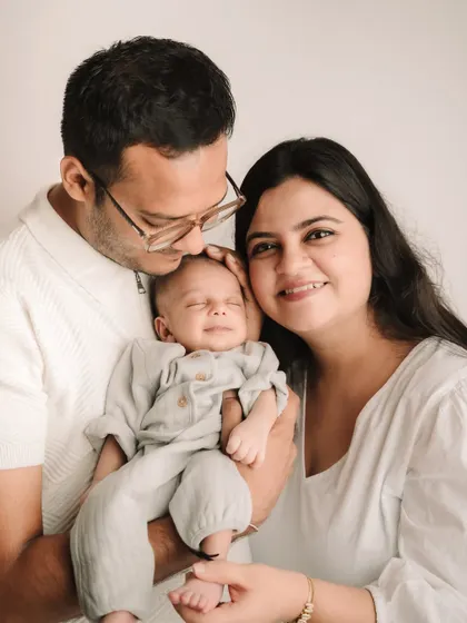 A perfect family moment, with the baby giving a tiny smile while being held by both parents. These are the unscripted moments of joy I love to capture.