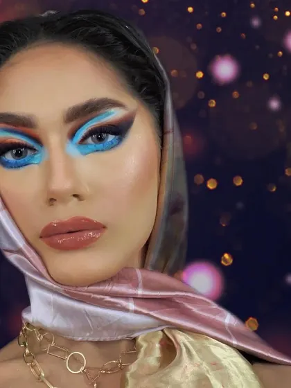 Bringing back the vibe of the 1950s. This look combines a vintage-style headscarf with a modern, bold blue graphic eye, creating a unique fusion of eras.