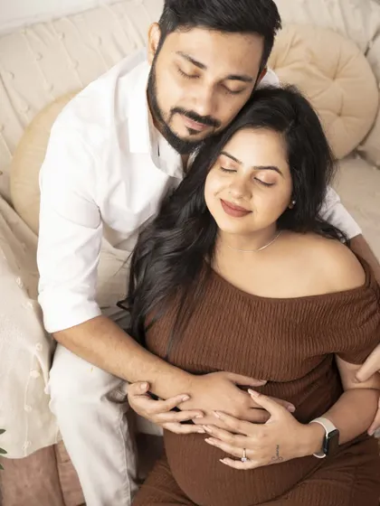 Pure happiness and peace. The couple's closed eyes and gentle smiles convey a sense of calm and contentment as they await their baby.