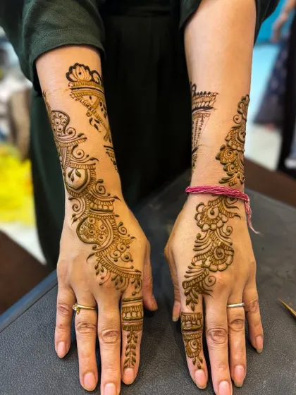 This stylish Arabic design runs along the side of the hand and up the arm, a popular and elegant choice for guests at sangeets and receptions.