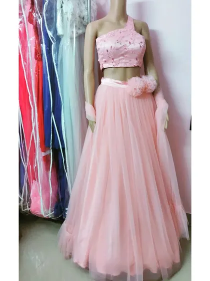 A pretty peach-pink lehenga with a sequined one-shoulder top and a delicate floral detail at the waist. A great option for a subtle, elegant look.