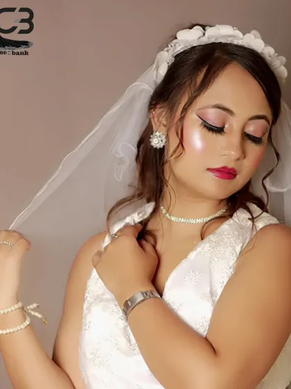 A serene and beautiful bridal portrait, with the model gently holding her veil.