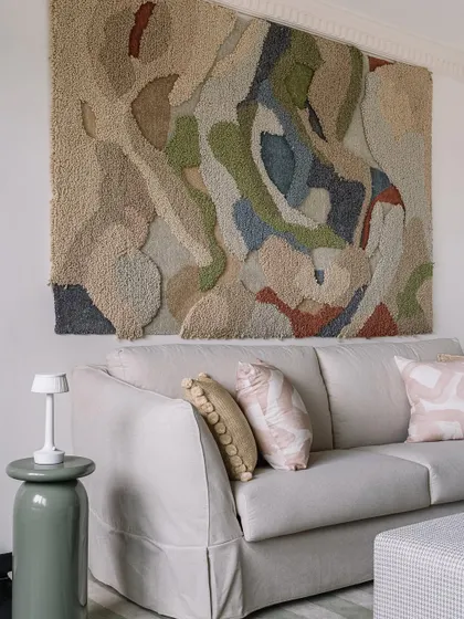 The home office lounge features a large, textural art piece and a comfortable sofa, making it an inspiring place to work or relax.