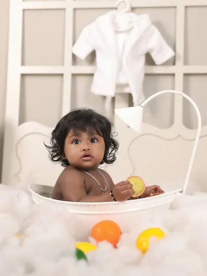 A fun and unique 'bubble bath' theme for a first birthday! This creative setup uses cotton clouds and colorful toys to simulate a playful bath time scene.