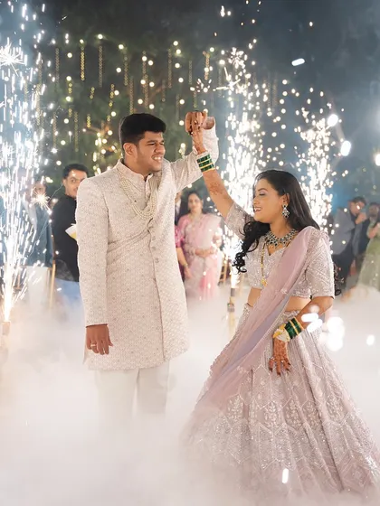 A magical moment as the couple dances, surrounded by sparklers. The bride's lehenga and open hairstyle are perfect for a night of celebration.