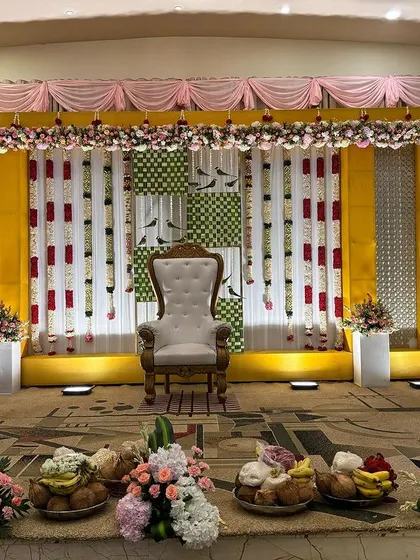 A simple stage with a yellow and green checkered backdrop, perfect for a puberty ceremony.