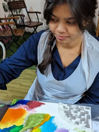 A participant engrossed in her abstract painting, blending colors and creating unique patterns.